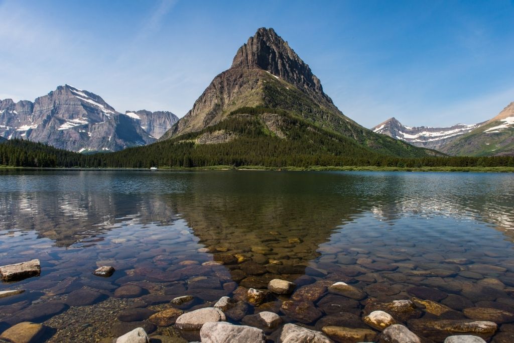 Sky and mountains reflect on Swiftcurrent lake making it the perfect location for an elopement 